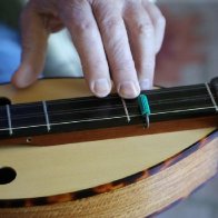 Closeup of Hennessy dulcimer with interesting capo design